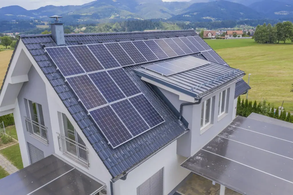 is my house suitable for solar panels? Close-up view of solar panels installed on a pitched tiled roof with a skylight. 