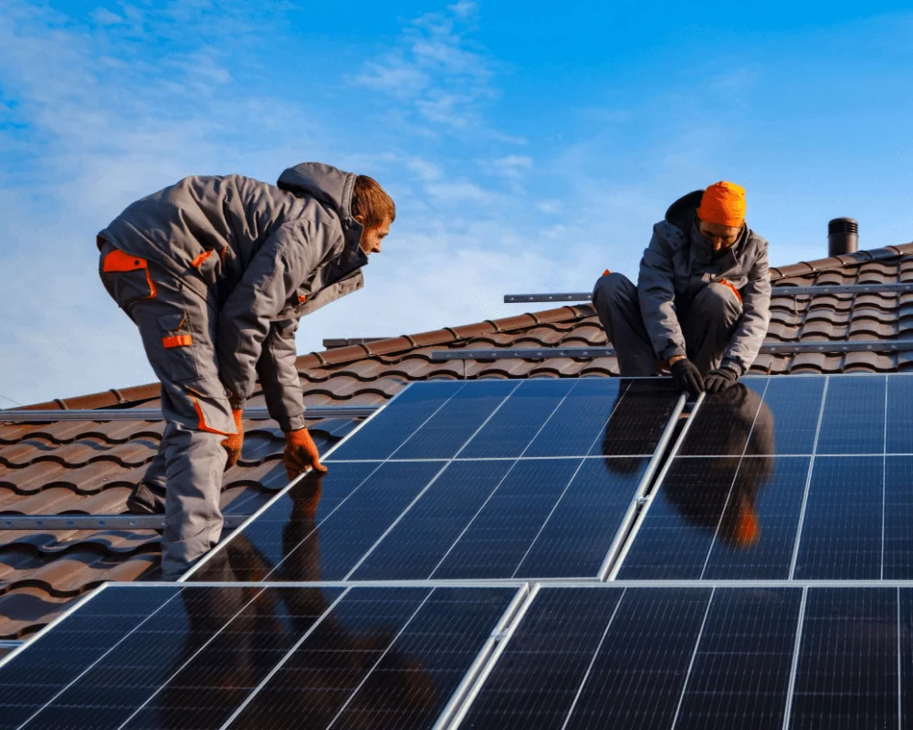 Soly installers are placing solar panels on a roof