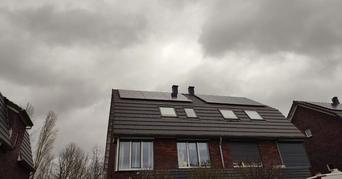 Solar panels mounted on the roof of a house under an overcast sky, designed for energy generation even in cloudy weather